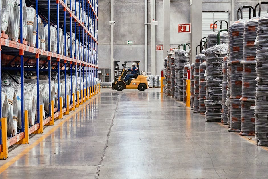 A forklift operates in an industrial warehouse with stacked goods. Efficient distribution setting.
